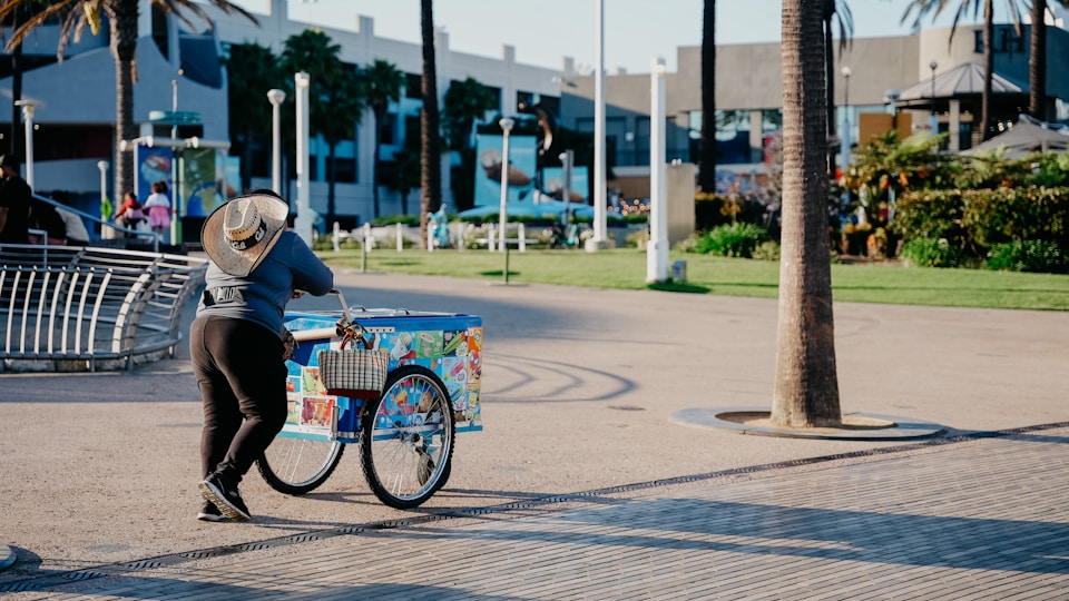 A man wheeling his ice cart