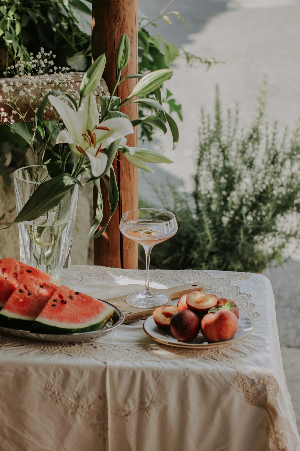 a table with a plate of fruit and a glass of wine