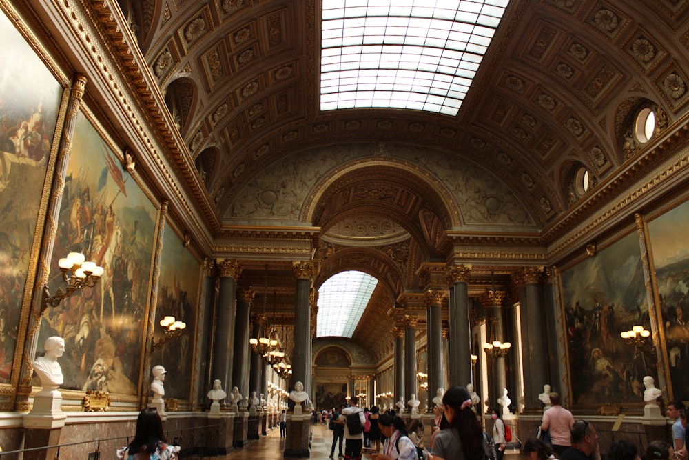 a large ornate room with statues and people