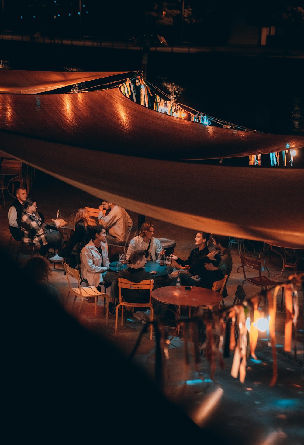 a group of people sitting at a table with a fire in the background