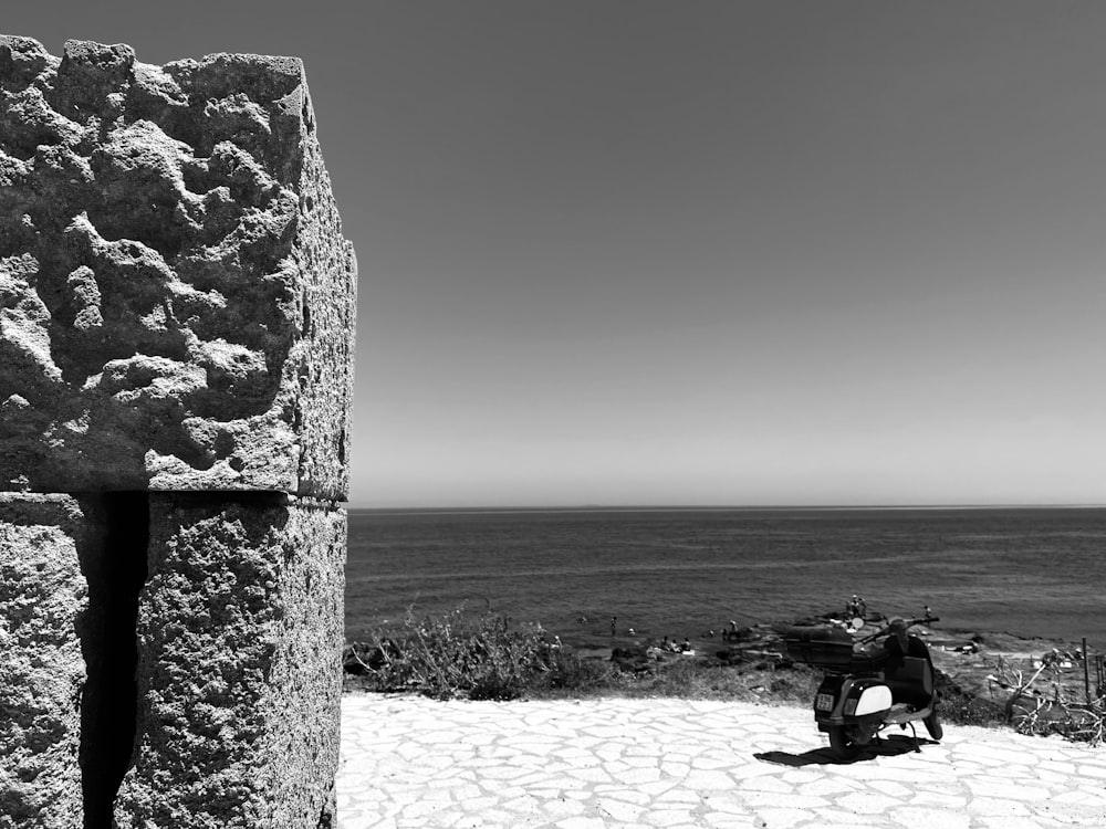 a stone archway with a beach and water in the background