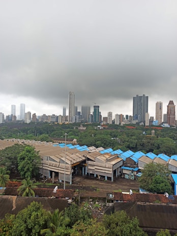 Exterior view of a warehouse terrace showing waterproofing work in progress under a cloudy sky.