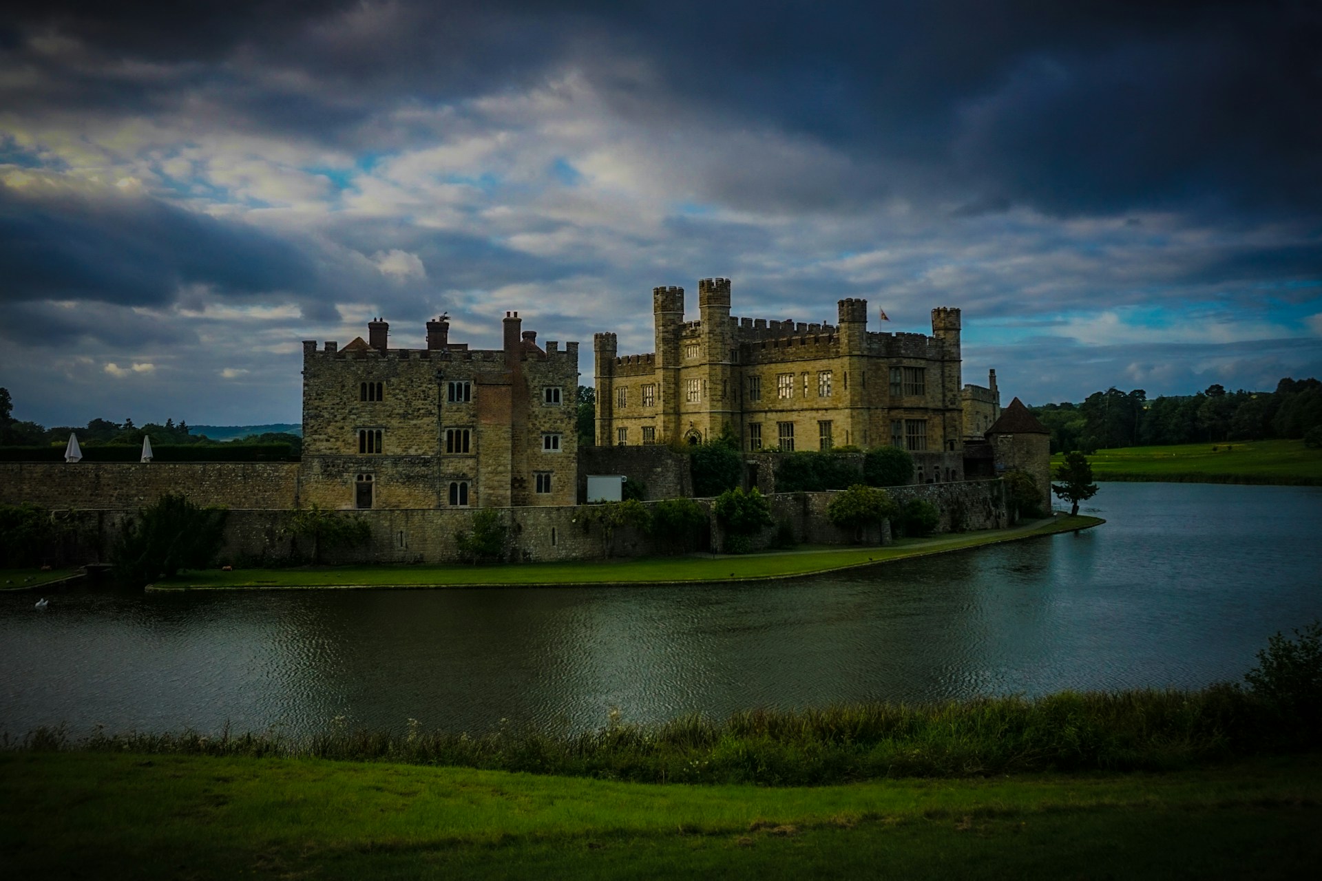 a large building next to a body of water with Leeds Castle in the background