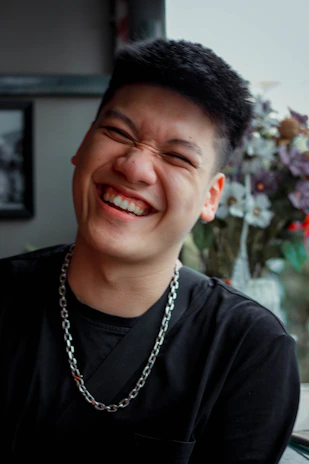 A customer smiling while wearing a shimmering chain from Ratnaluxe.