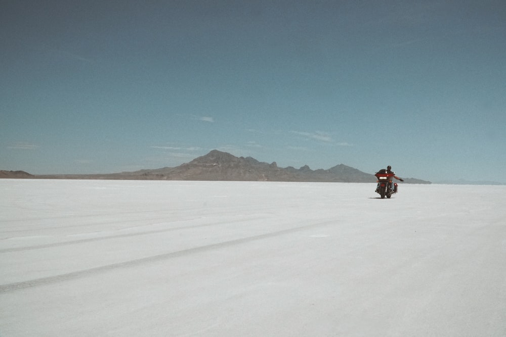 a person riding a motorcycle in a snowy field