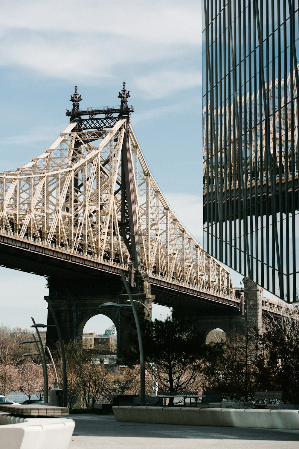a large metal bridge with Queensboro Bridge in the background