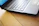 A close-up of a modern laptop on a wooden desk.