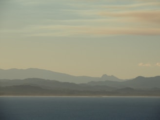 a body of water with hills in the background