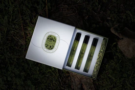 An artfully arranged gift box with assorted perfume bottles and oils wrapped in soft fabric