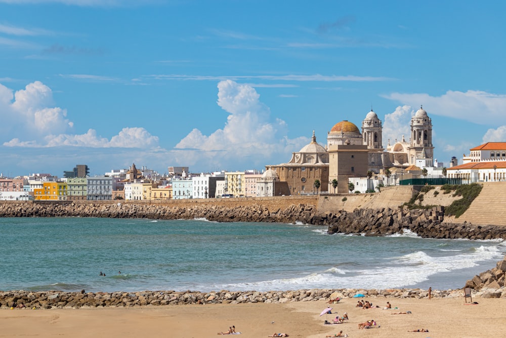 a beach with buildings and a body of water in the background