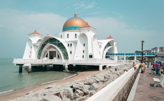 a white building with a domed roof by water