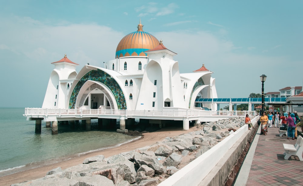 a white building with a domed roof by water