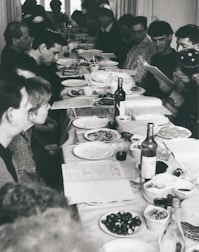 A group of people sharing a meal and laughter around a large table.