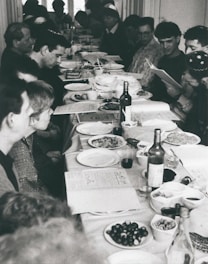 A diverse group of people sharing a meal at a community table.