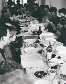 Members gathered around a long table sharing homemade Portuguese dishes at a festive event.