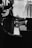 Hands playing a grand piano with an elegant and formal atmosphere, captured in black and white tones. The piano keys and hands are in sharp focus while the background remains softly blurred.