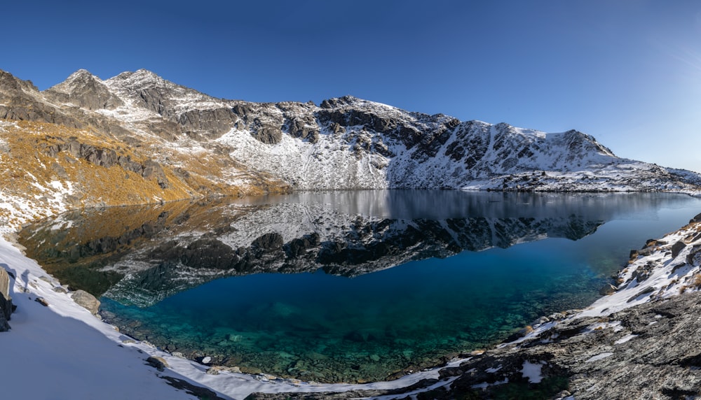 a lake surrounded by snow covered mountains