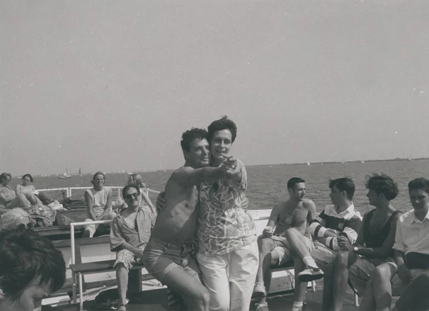 A lively group dancing on the deck of a boat under string lights on a warm summer evening.