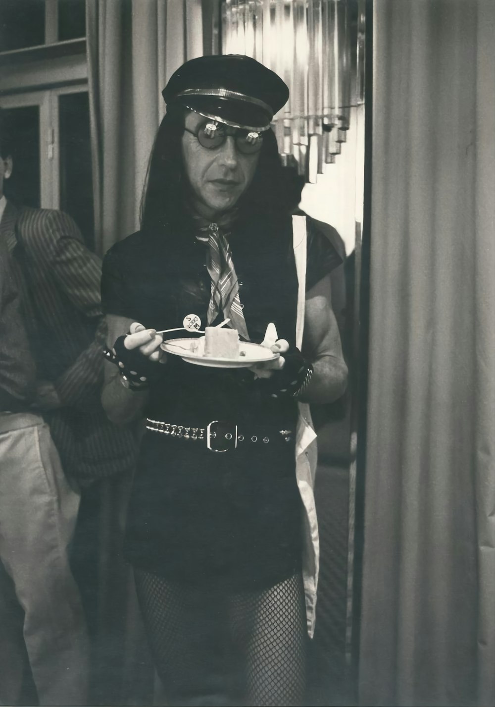 a person wearing a graduation cap and gown holding a cake