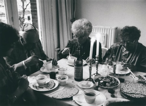 A group of married scholars engaged in lively Torah discussion around a wooden table.