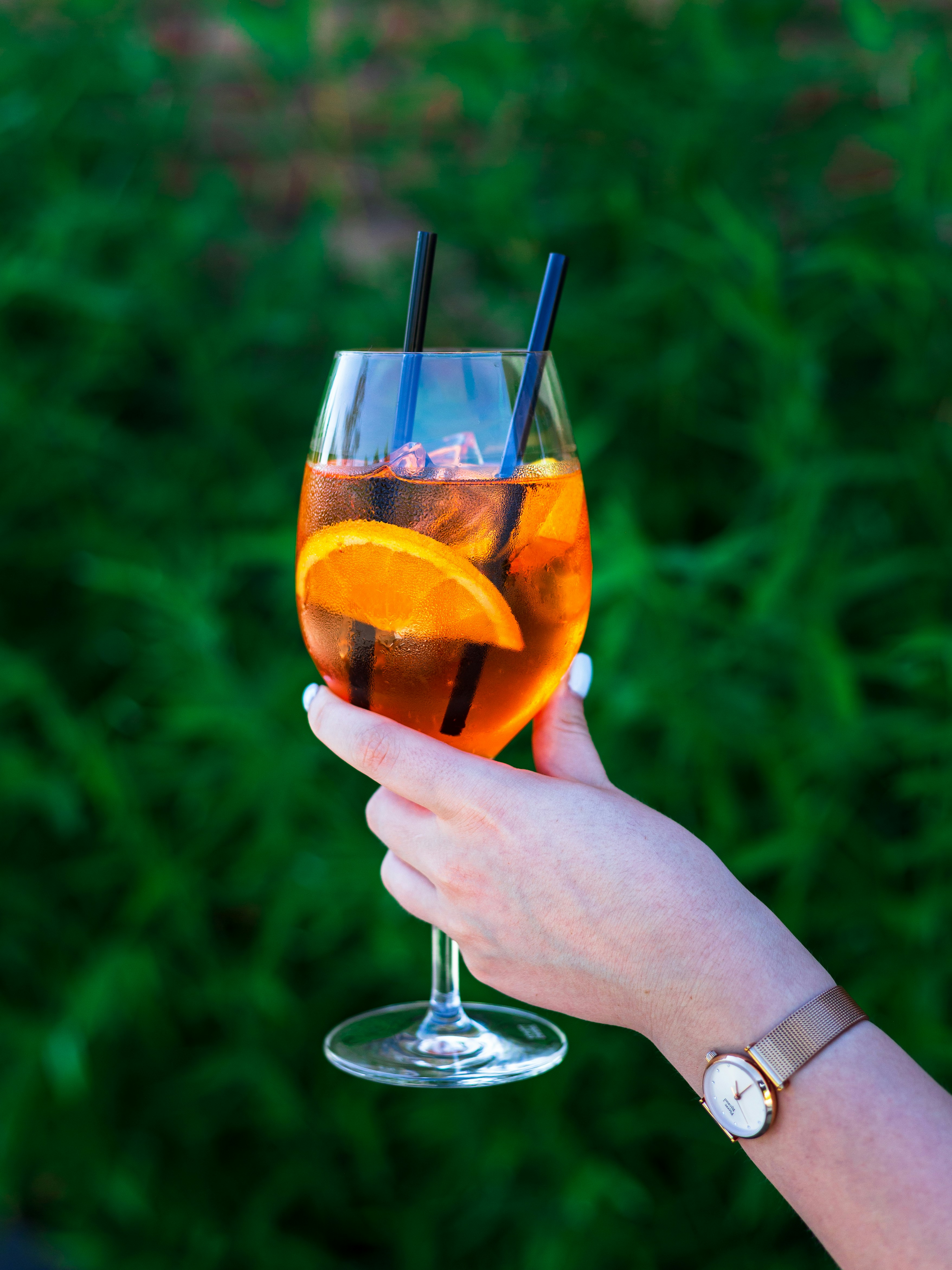 a hand holding a glass with a drink in it