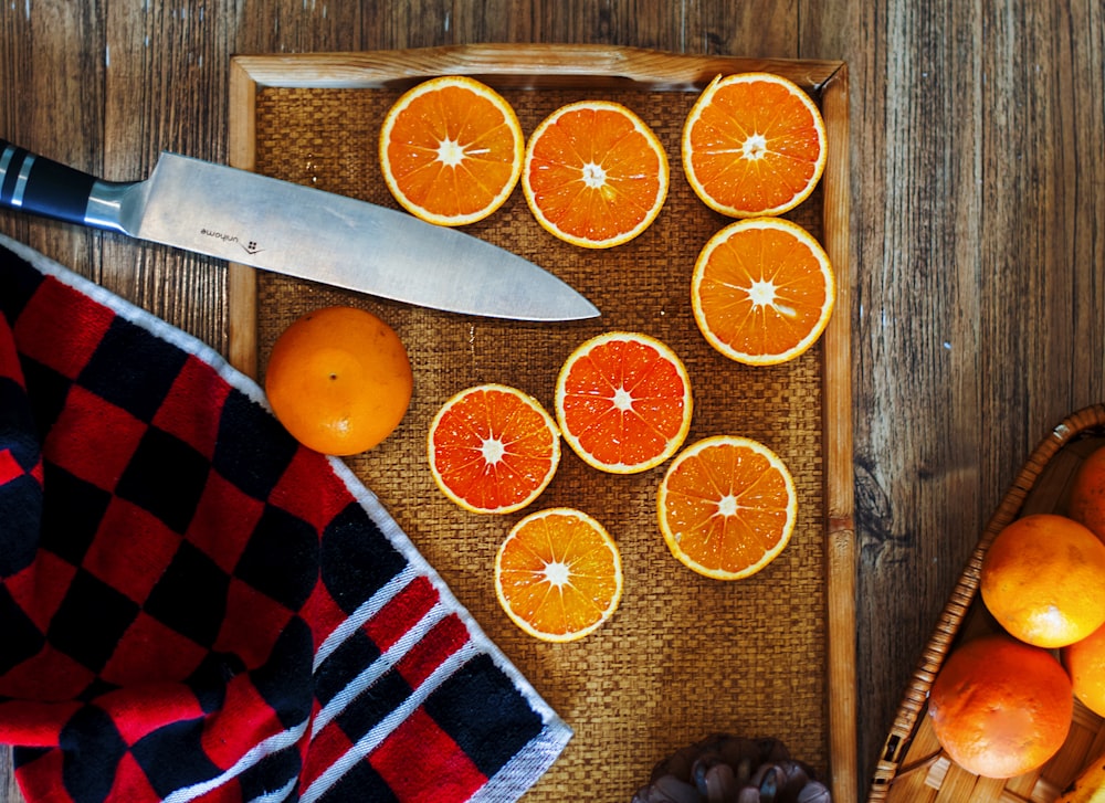 a knife next to a bunch of oranges
