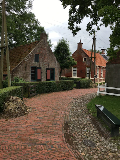 A charming village pathway winding through colorful traditional houses surrounded by lush greenery.