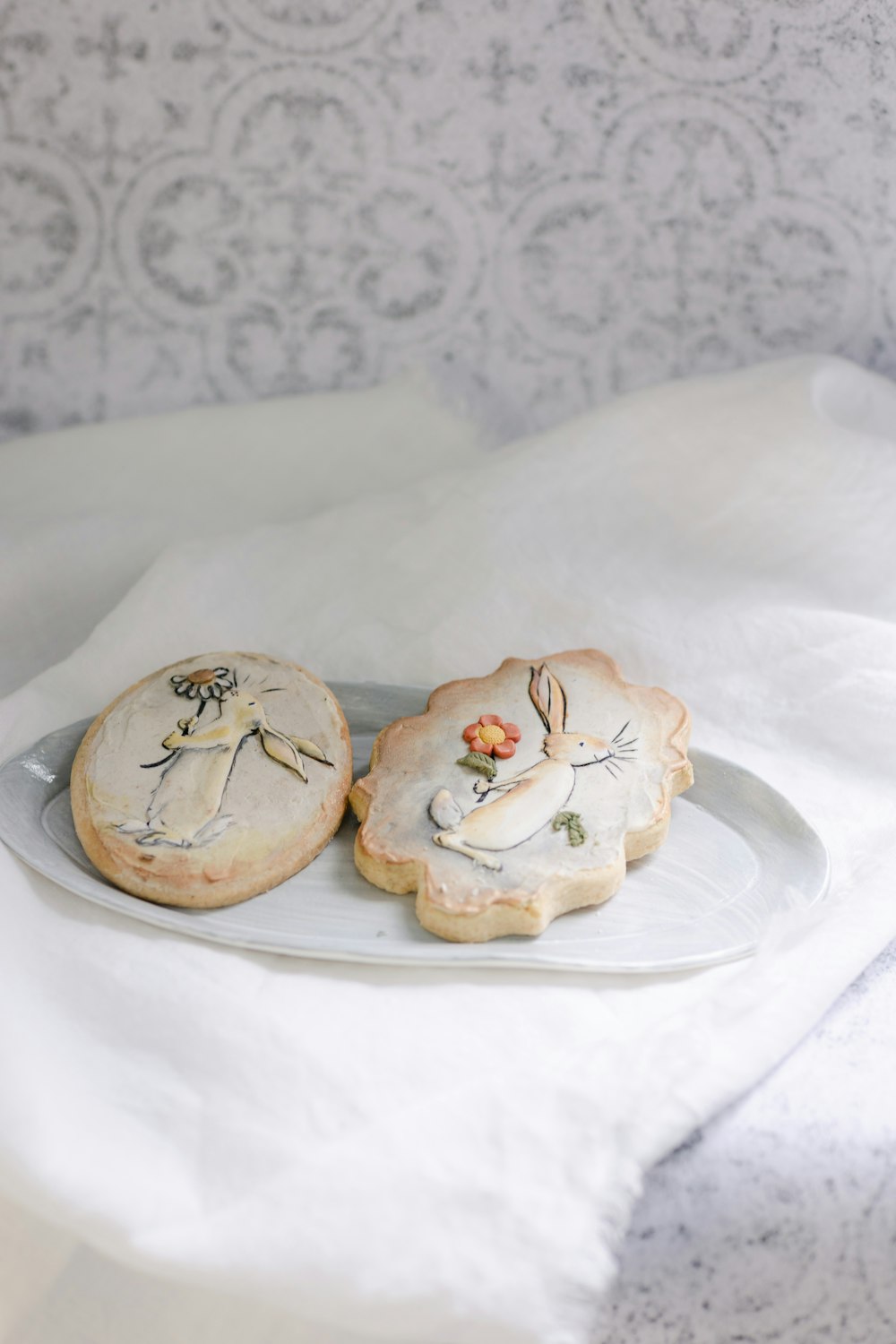 a pair of white slippers with flowers on a white plate