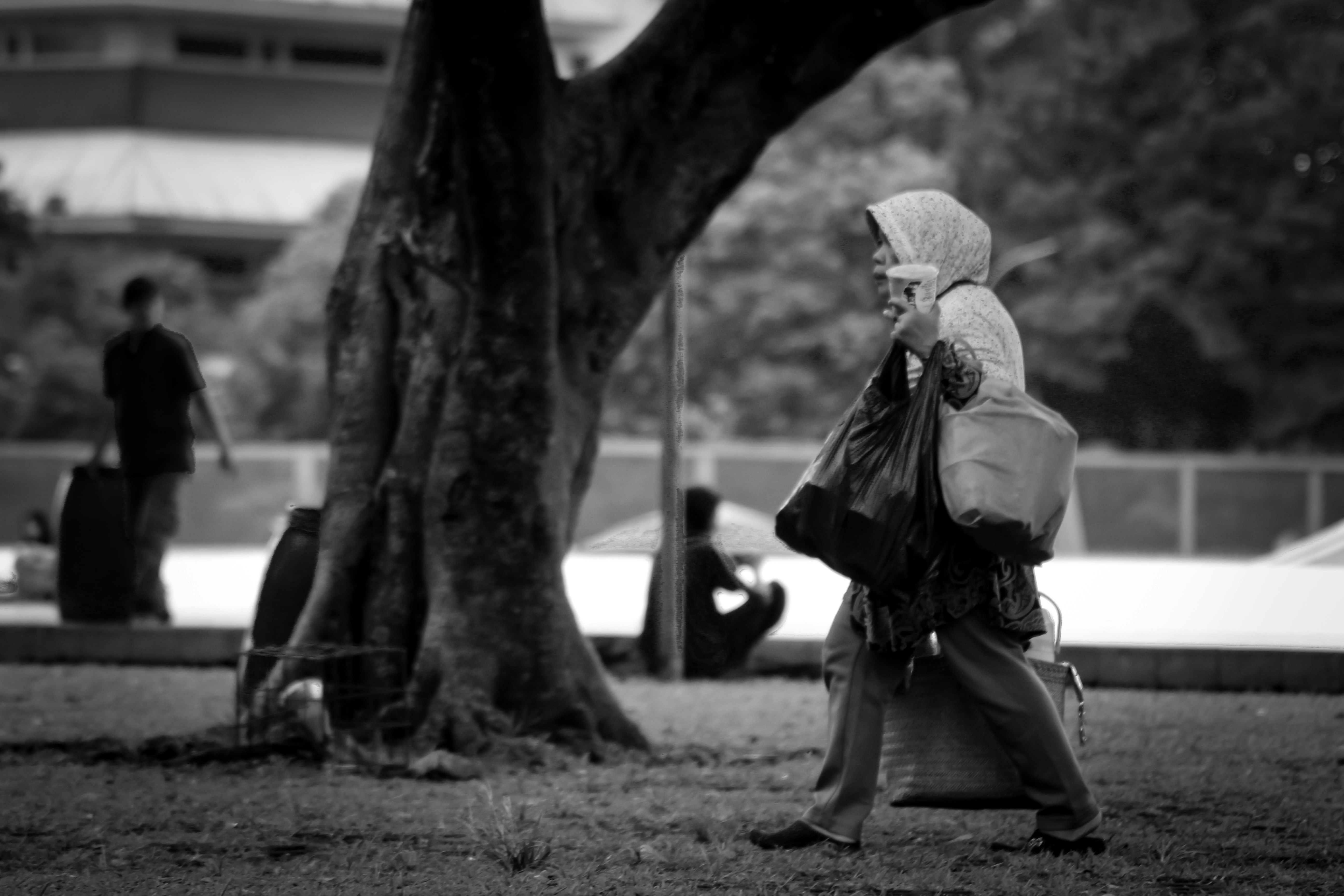 Eine Person mit Hut und Mantel, die mit dem Handy telefoniert