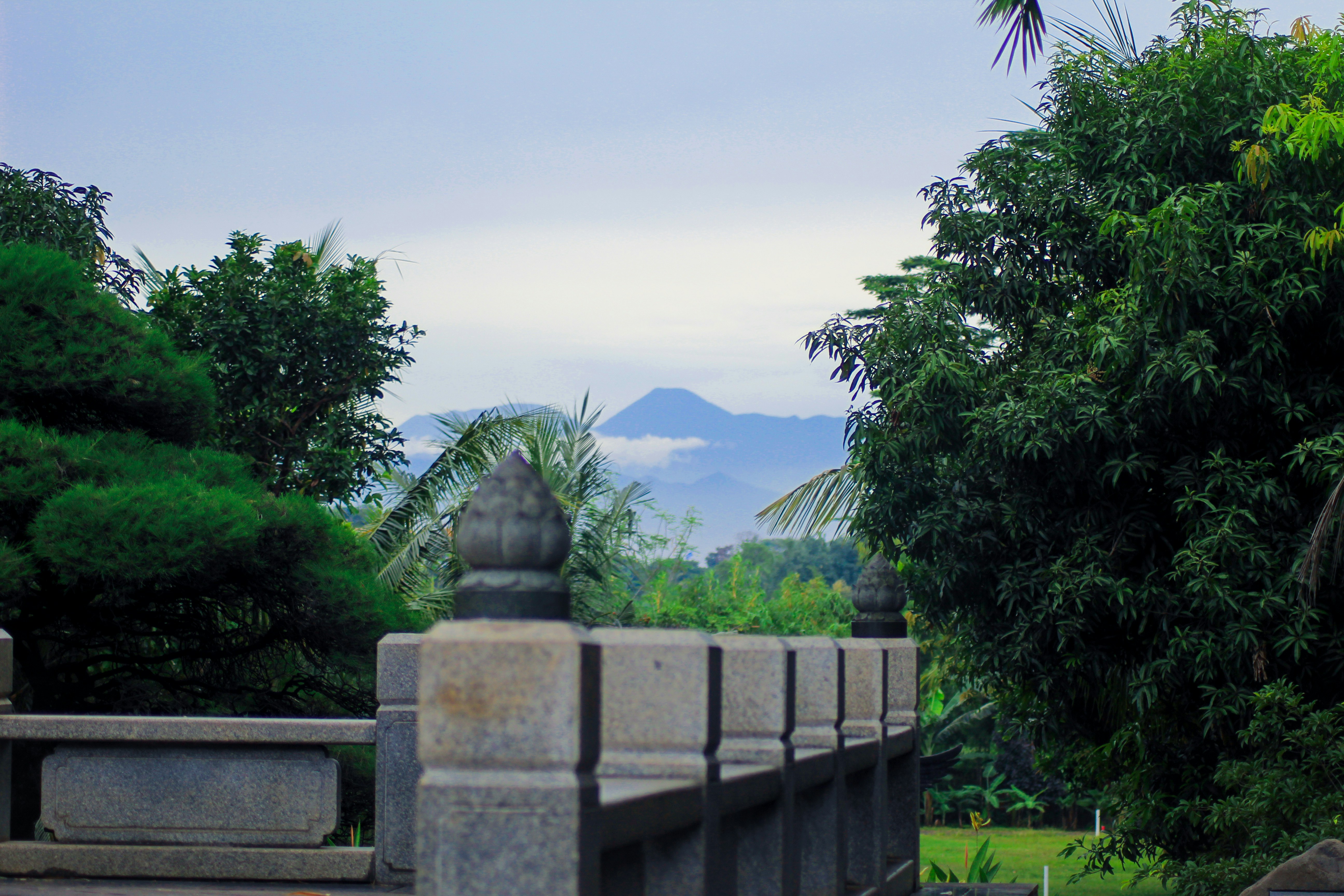 a stone fence with a statue in the middle of it