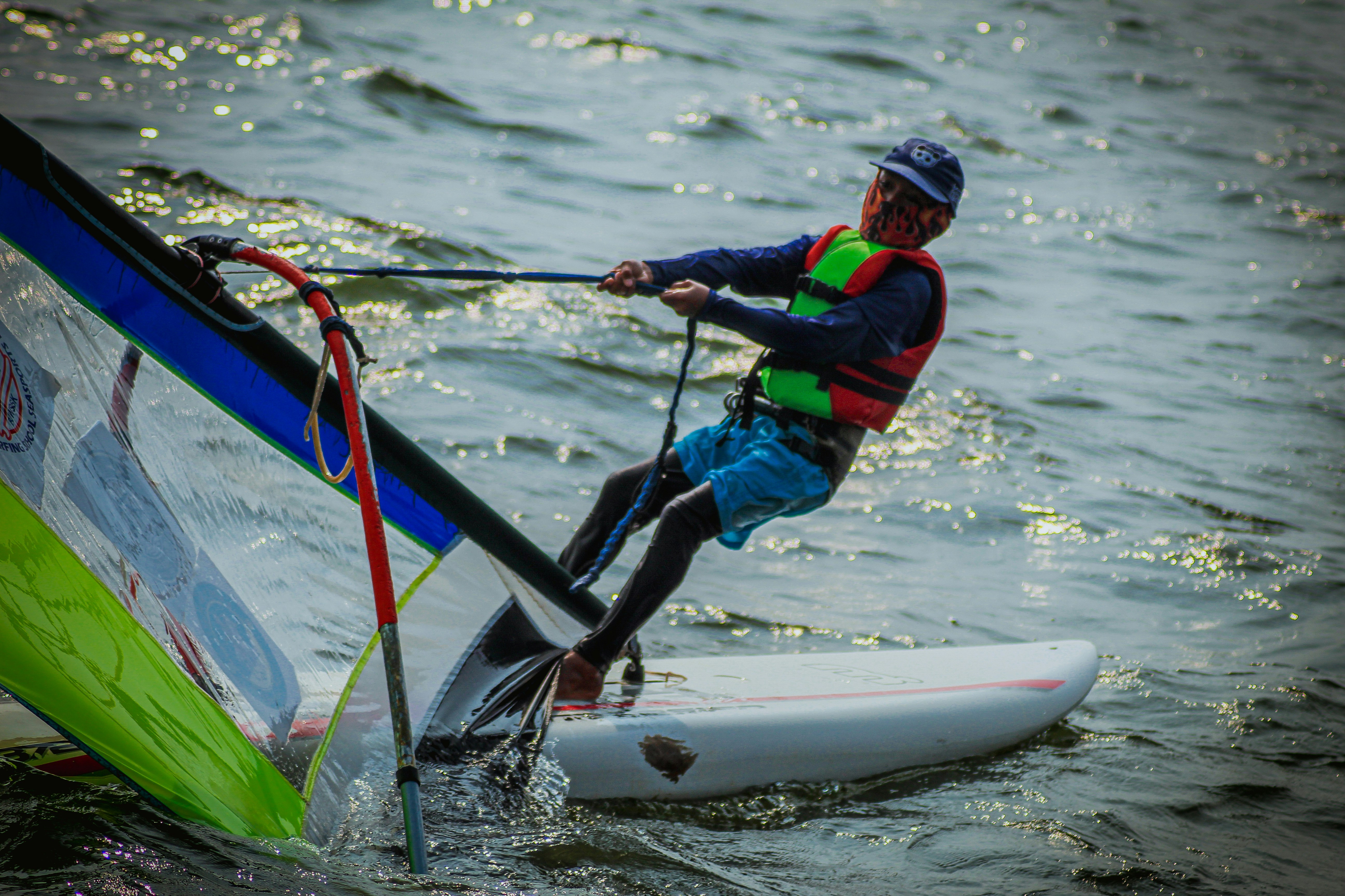eine Person in einer Schwimmweste auf einem Surfbrett