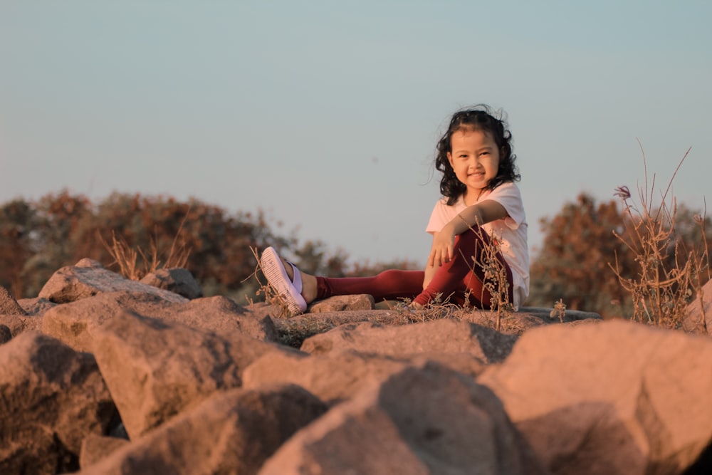 a girl sitting on a rock