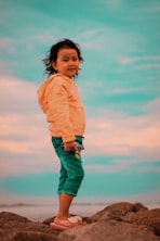 a young girl standing on a rock