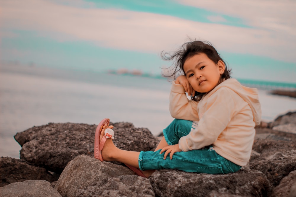 a child sitting on a rock