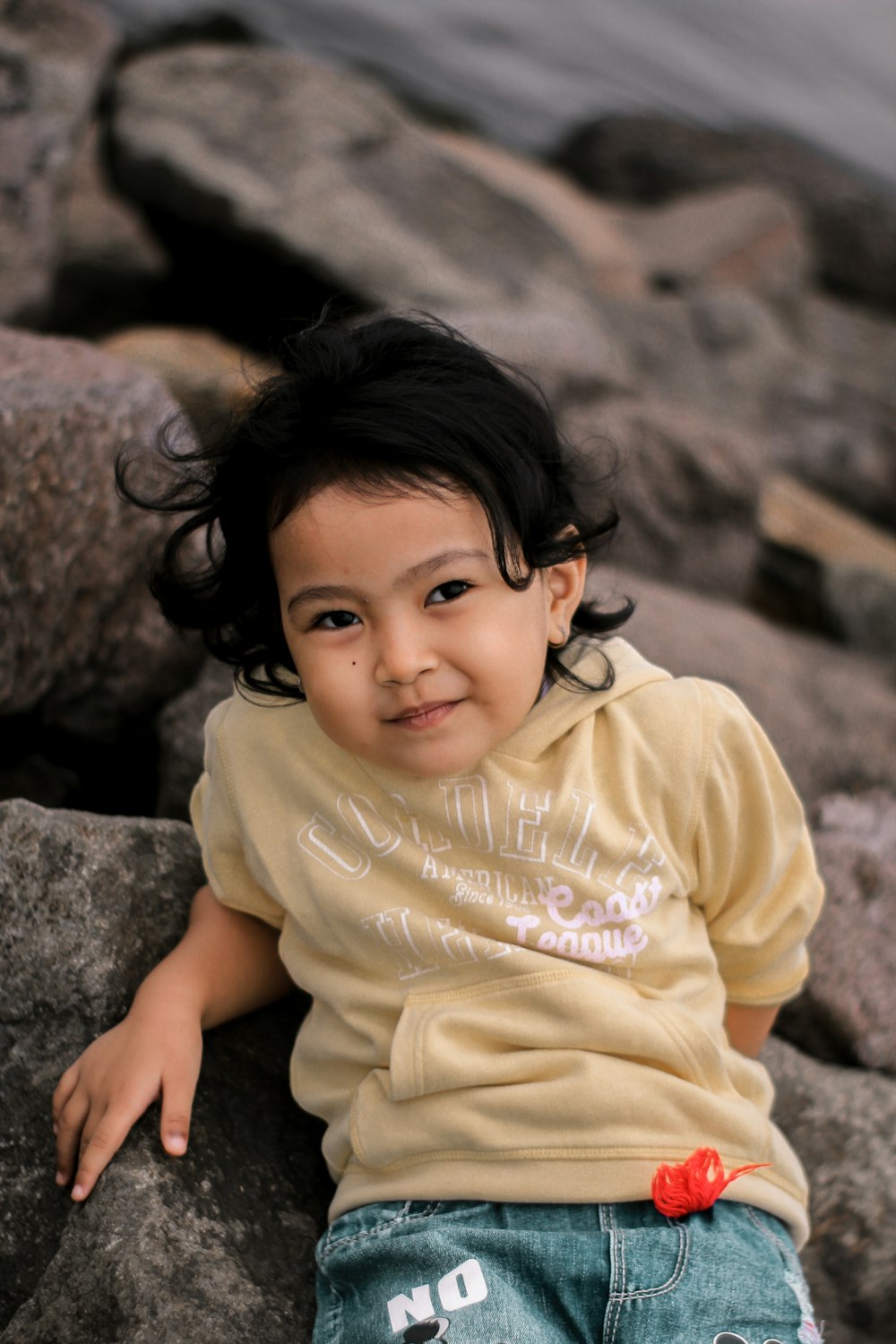 a young girl standing on a rock