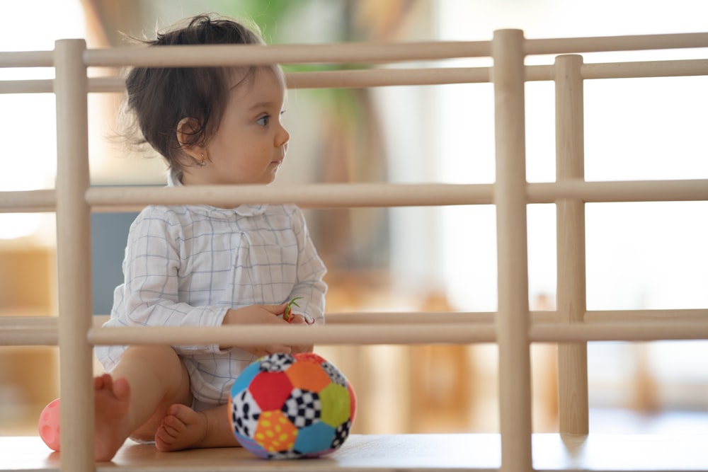 a baby playing with a ball
