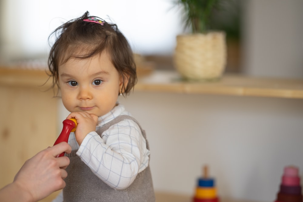 a little girl holding a toy