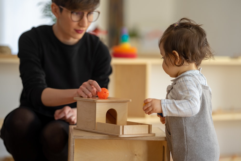 a person and a child playing with a toy