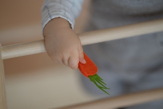 Close-up of a child’s hand holding a bright yellow toy with rounded edges, highlighting the safe, odorless material.