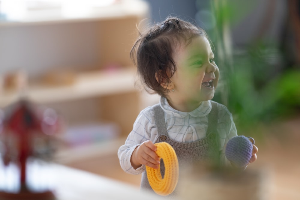 a little girl holding a yellow ball