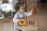 Smiling toddler wearing a colorful boutique outfit playing with a wooden toy.