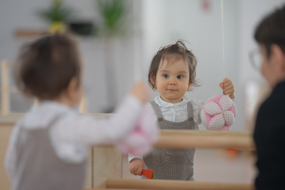 a baby girl holding a toy