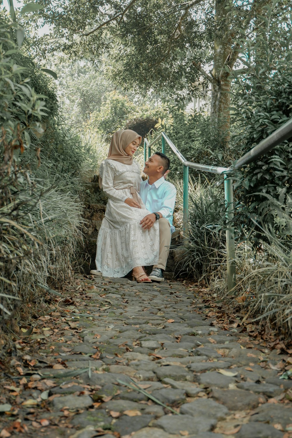 a person holding a child on a stone path in a forest