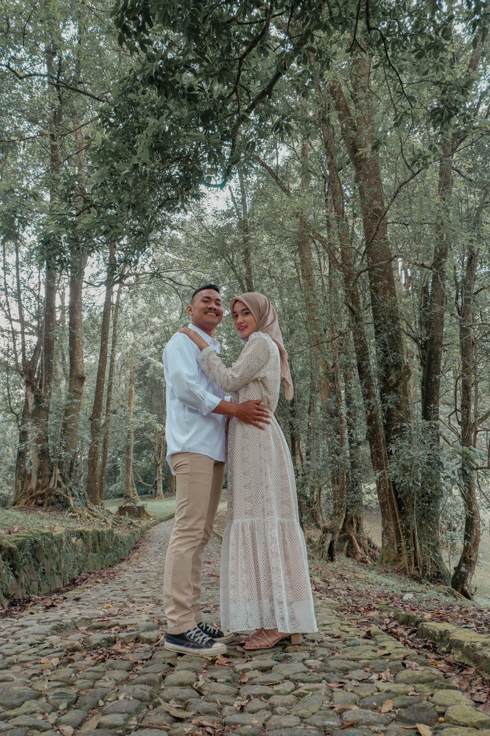 Un hombre y una mujer posando para una foto en un bosque