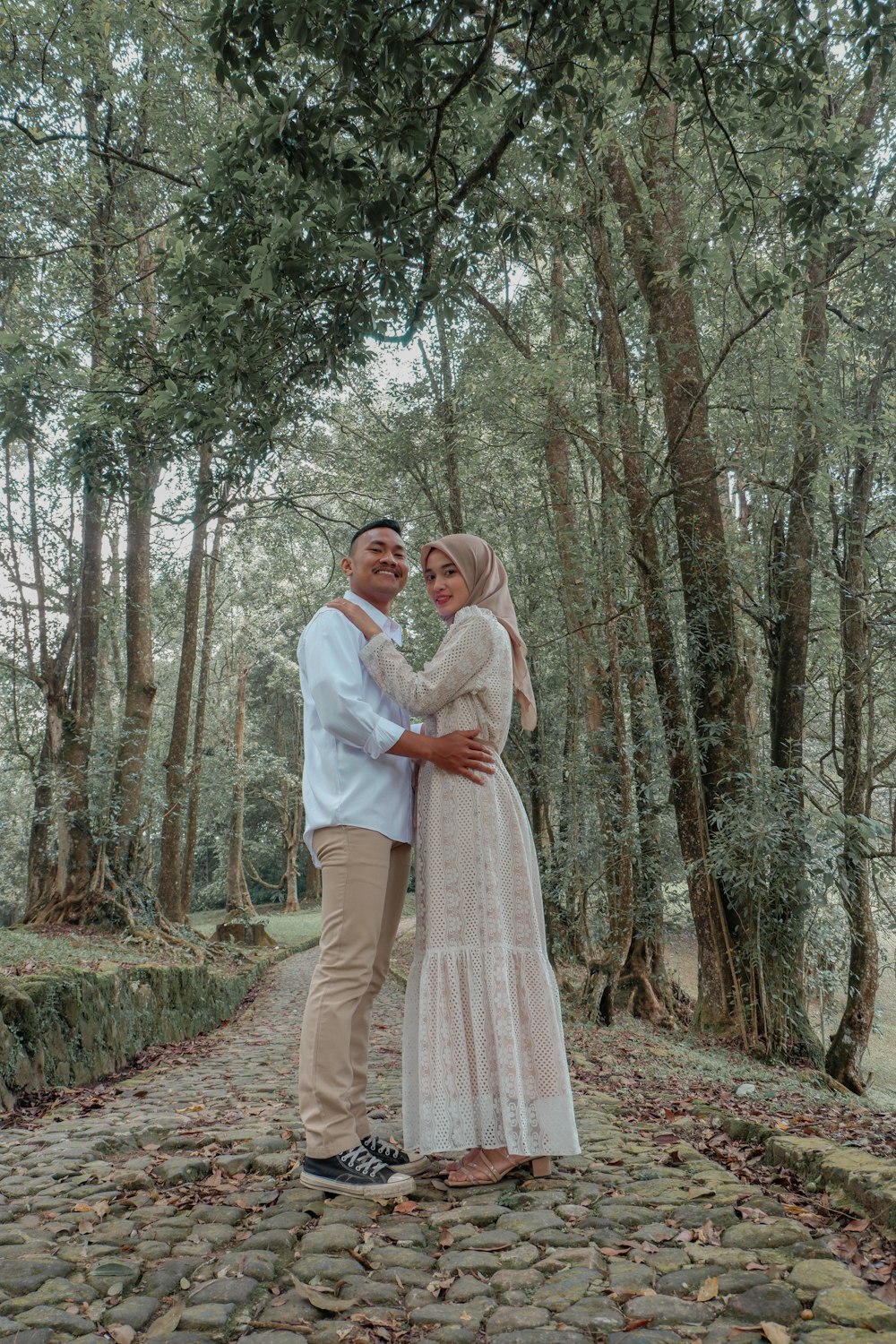 Un uomo e una donna in posa per una foto in una foresta