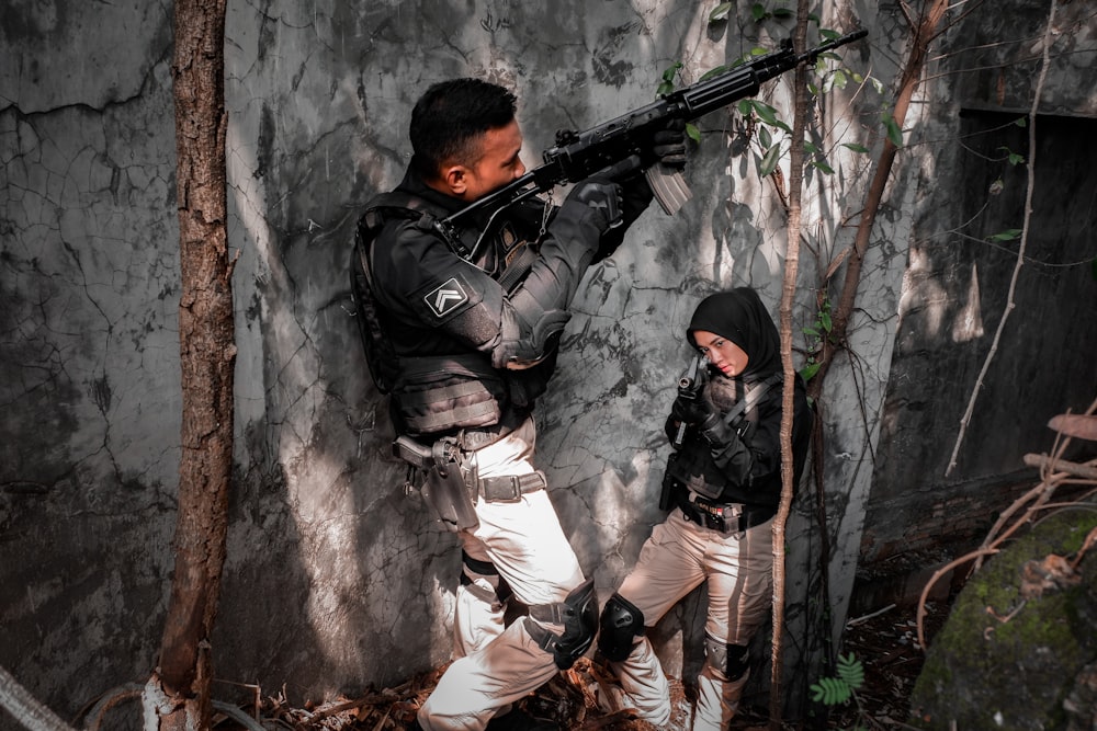 a man holding a gun and another man holding a gun