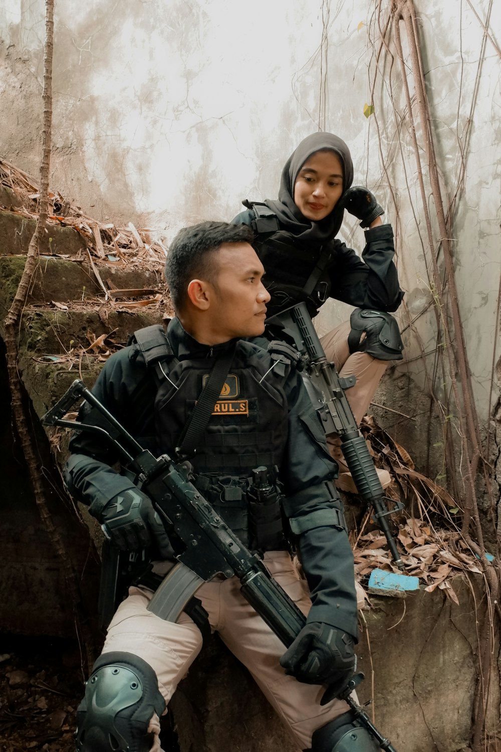 a man holding a gun and a woman in a helmet
