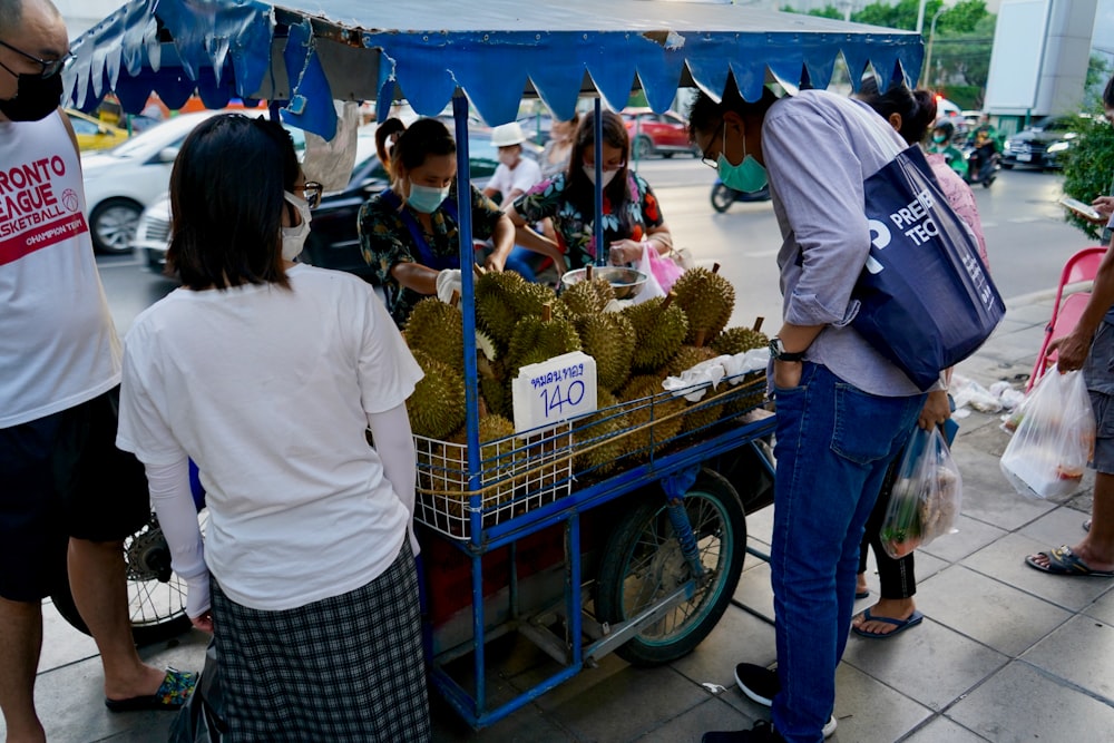 people standing around a fruit stand