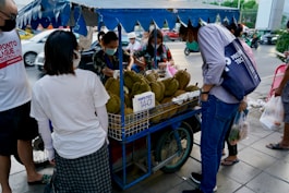 people standing around a fruit stand