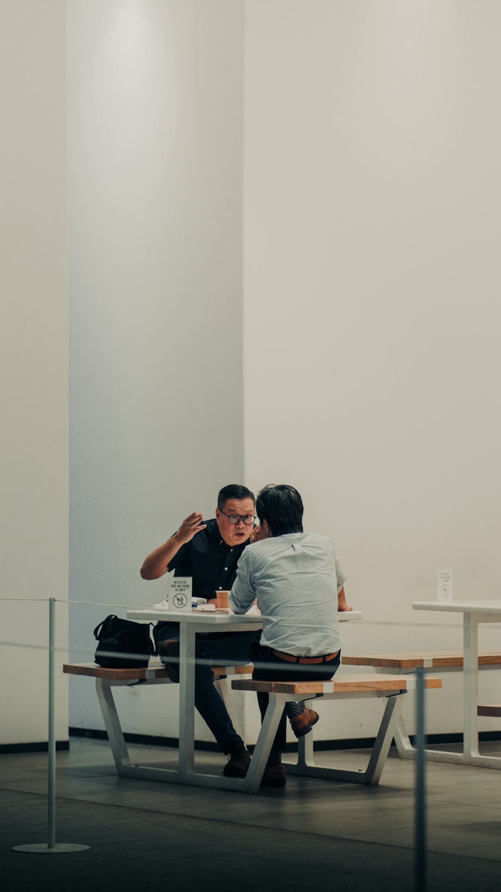 a person sitting at a table with another man sitting at a table